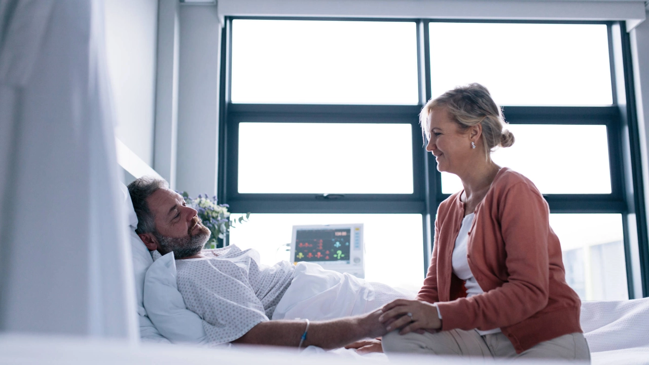 Eine Frau besucht einen Mann im Krankenhaus. 