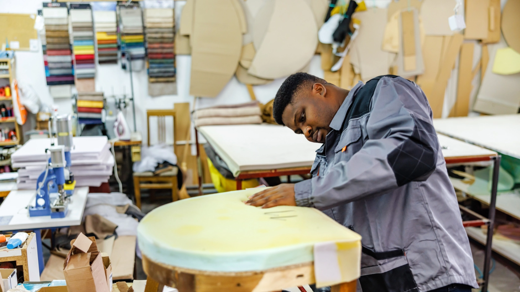 Ein Mann polstert einen Stuhl neu in einer Werkstatt.
