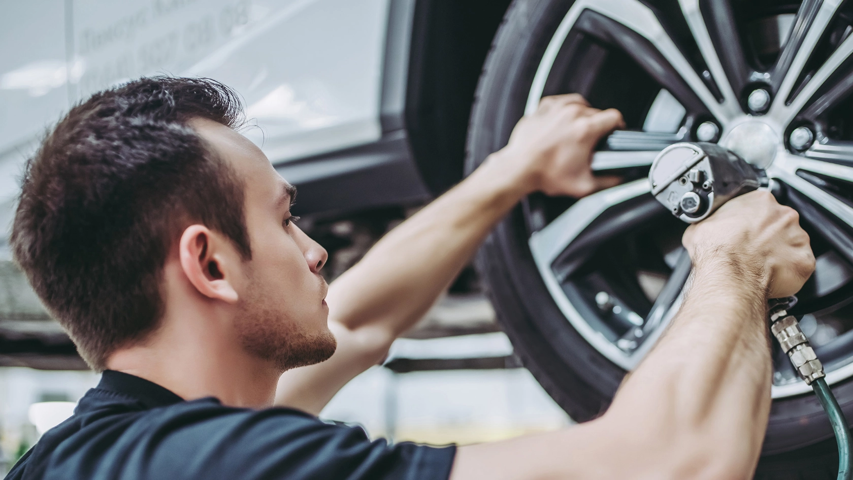 Mechaniker montiert einen Autoreifen fest