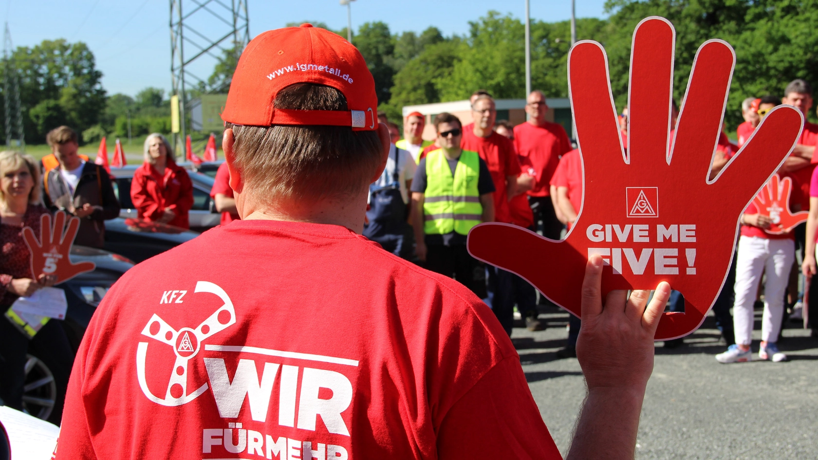 Ein Mann trägt eine IG-Metall-Kappe und ein rotes Shirt auf dessen Rücken steht: Wir für mehr. Stark im Handwerk.