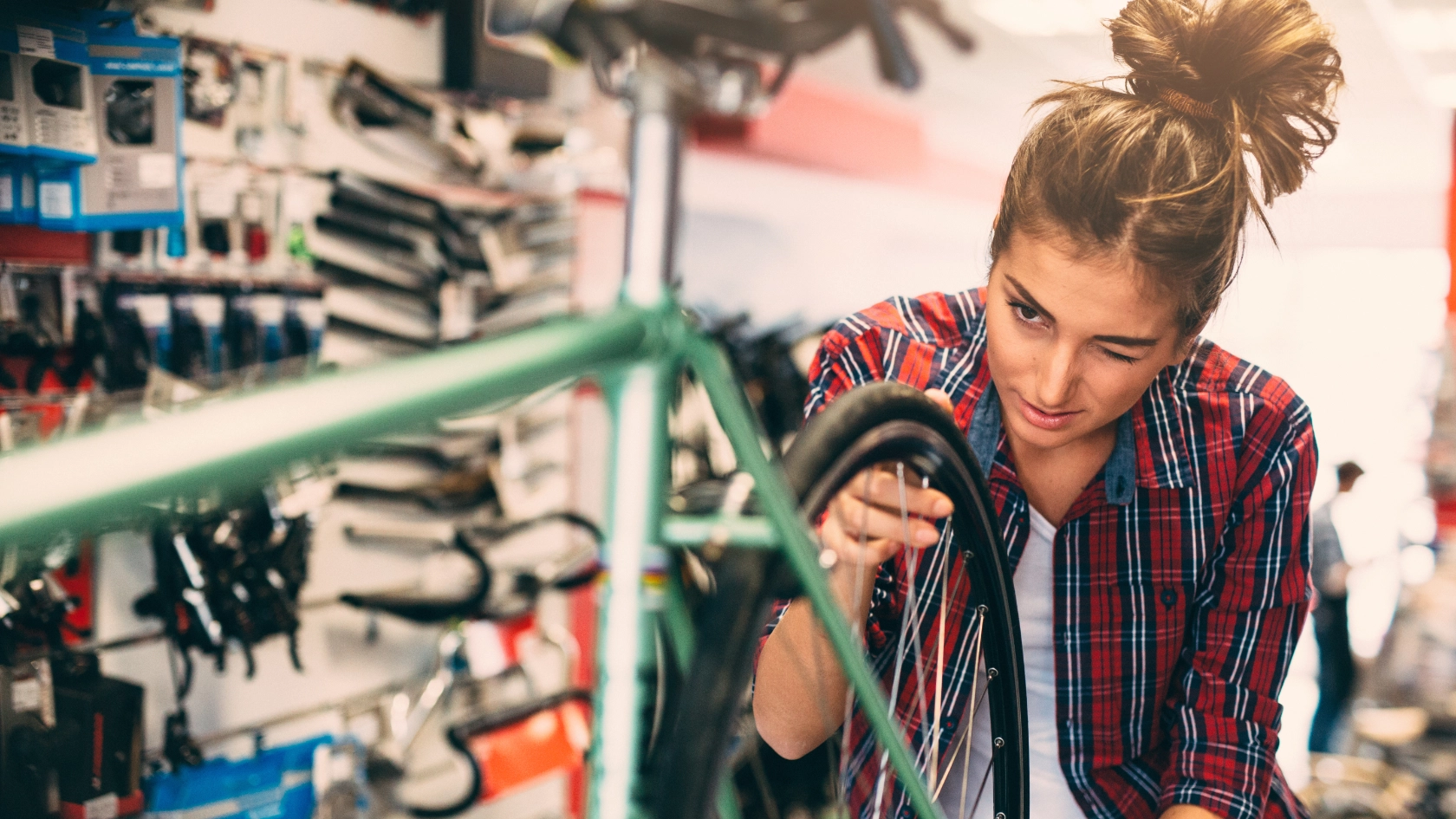 Eine Zweiradmechanikerin arbeitet an einem Fahrrad in einer Werkstatt 