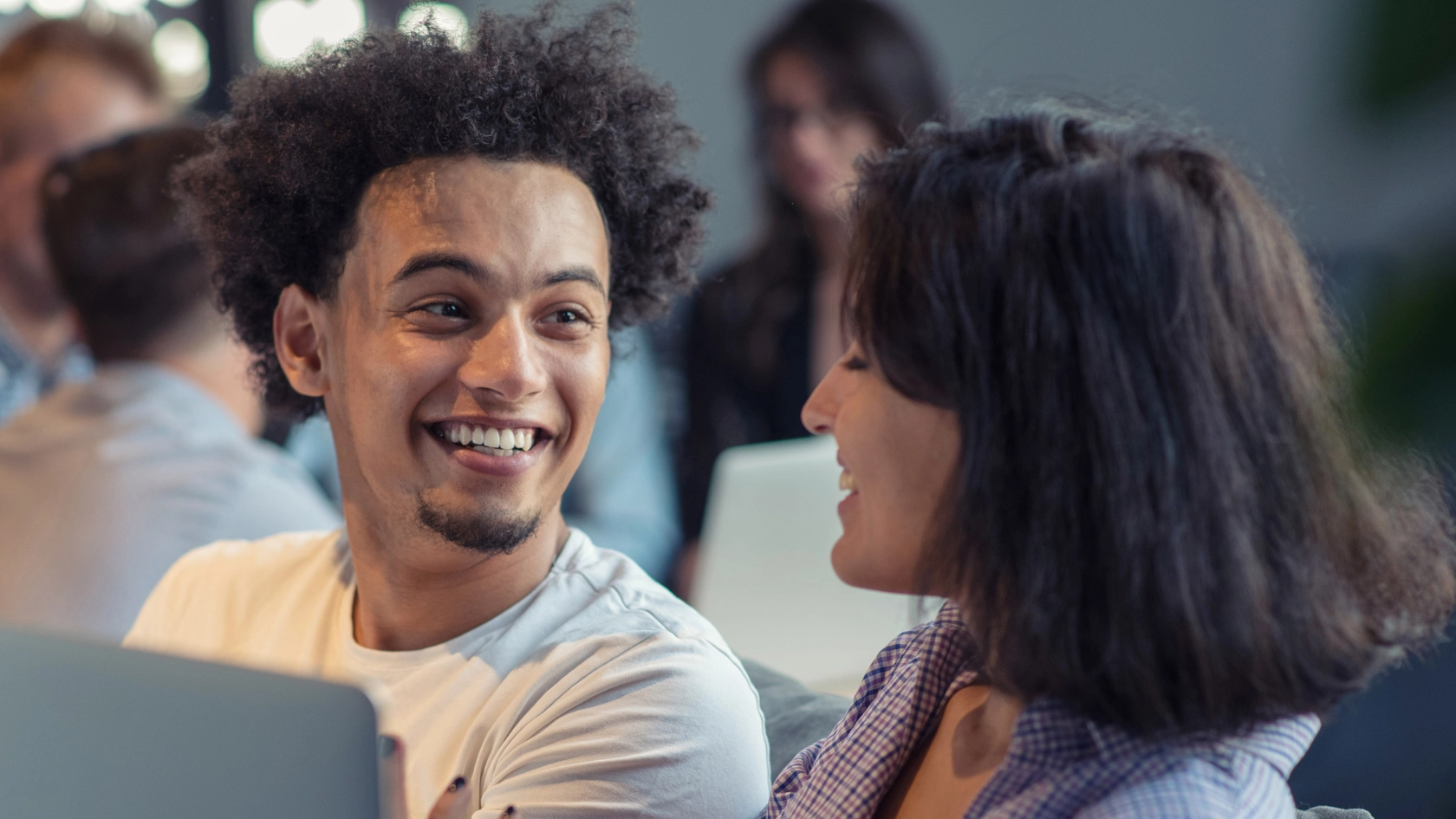 Junger Mann und eine junge Frau unterhalten sich im Büro