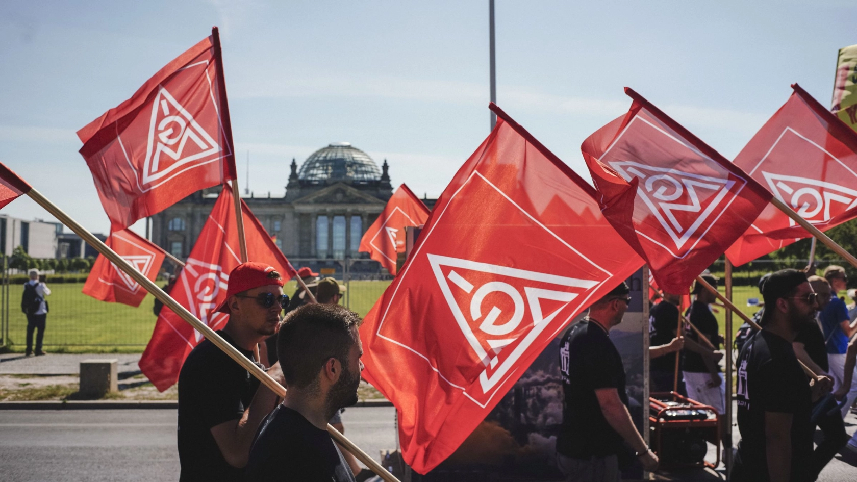Metaller laufen mit IG Metall-Fahnen am Bundestag in Berlin vorbei zur FairWandel-Kundgebung