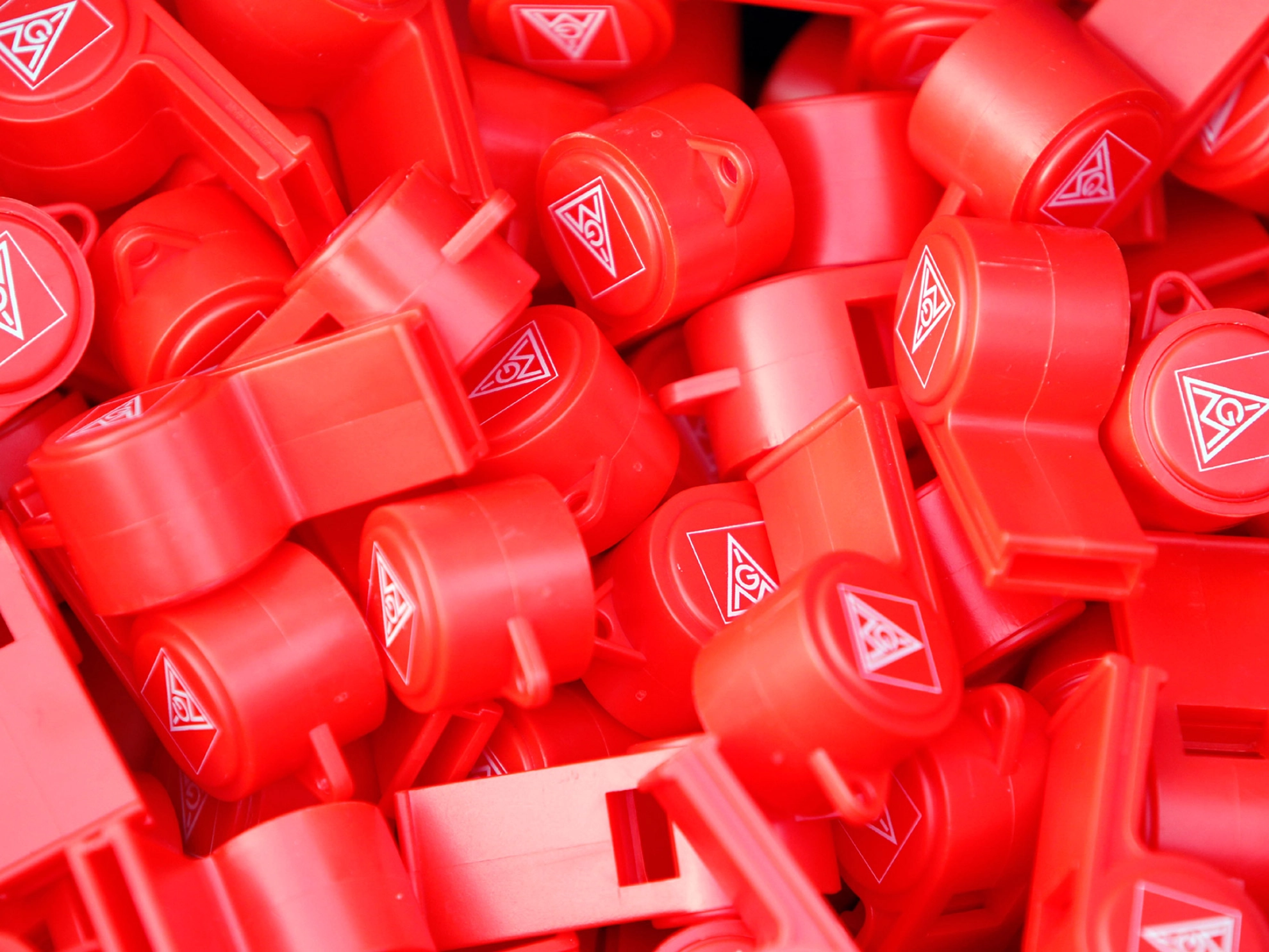 Viele rote Trillerpfeifen mit dem Logo der IG Metall.